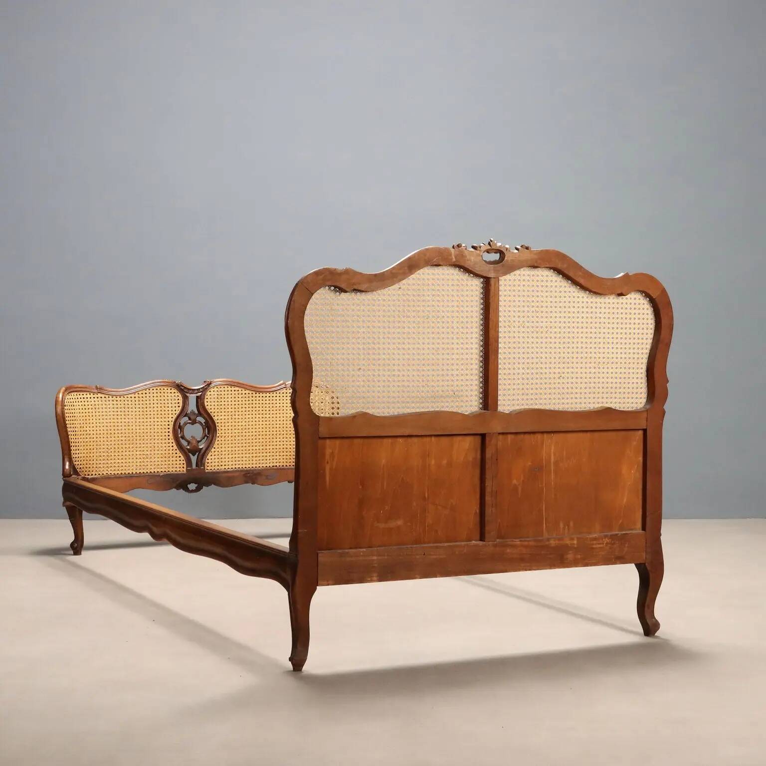 Simple bed in Barocchetto style in walnut.