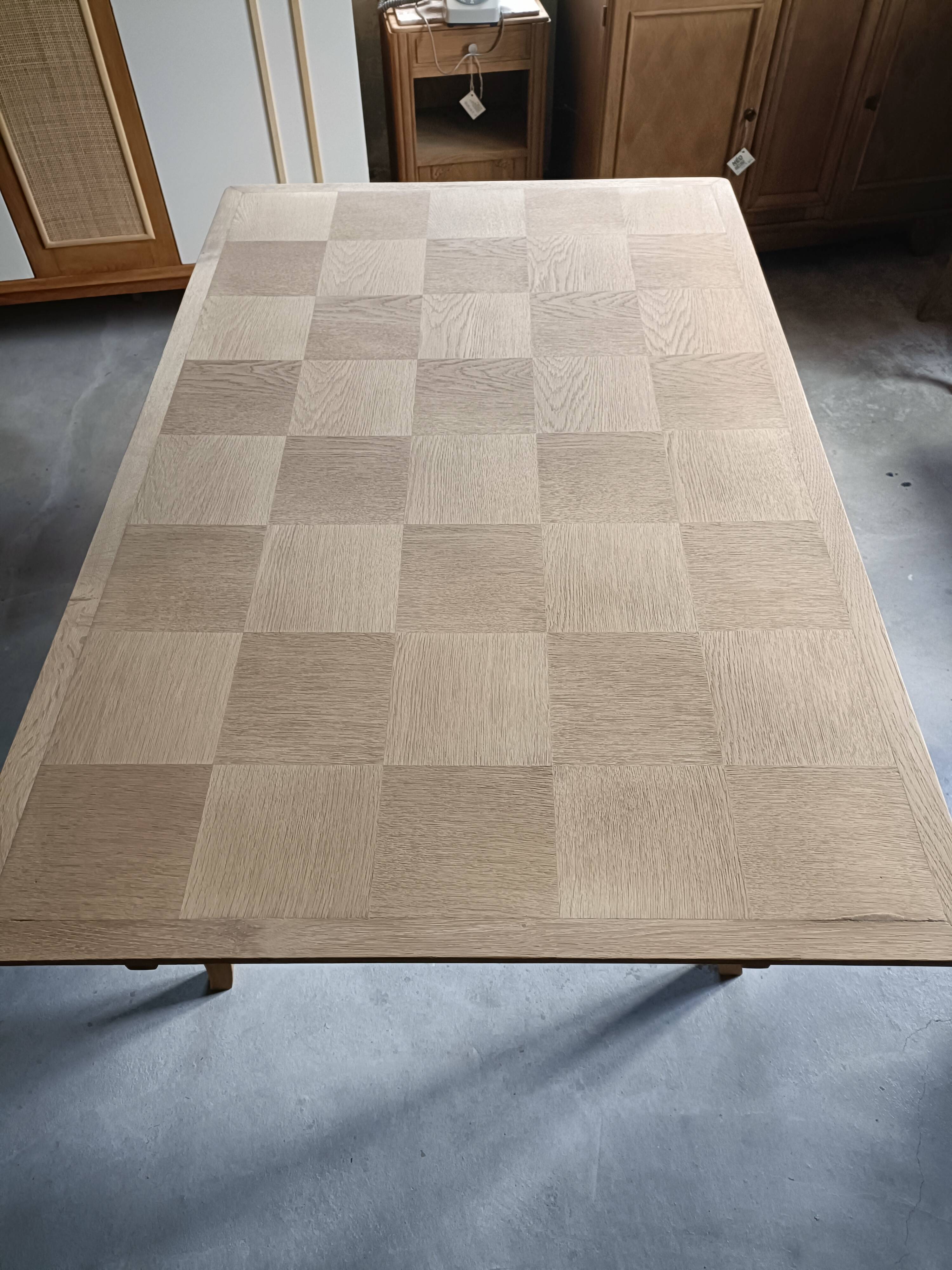 Oak dining table with a checkerboard top and extensions.
