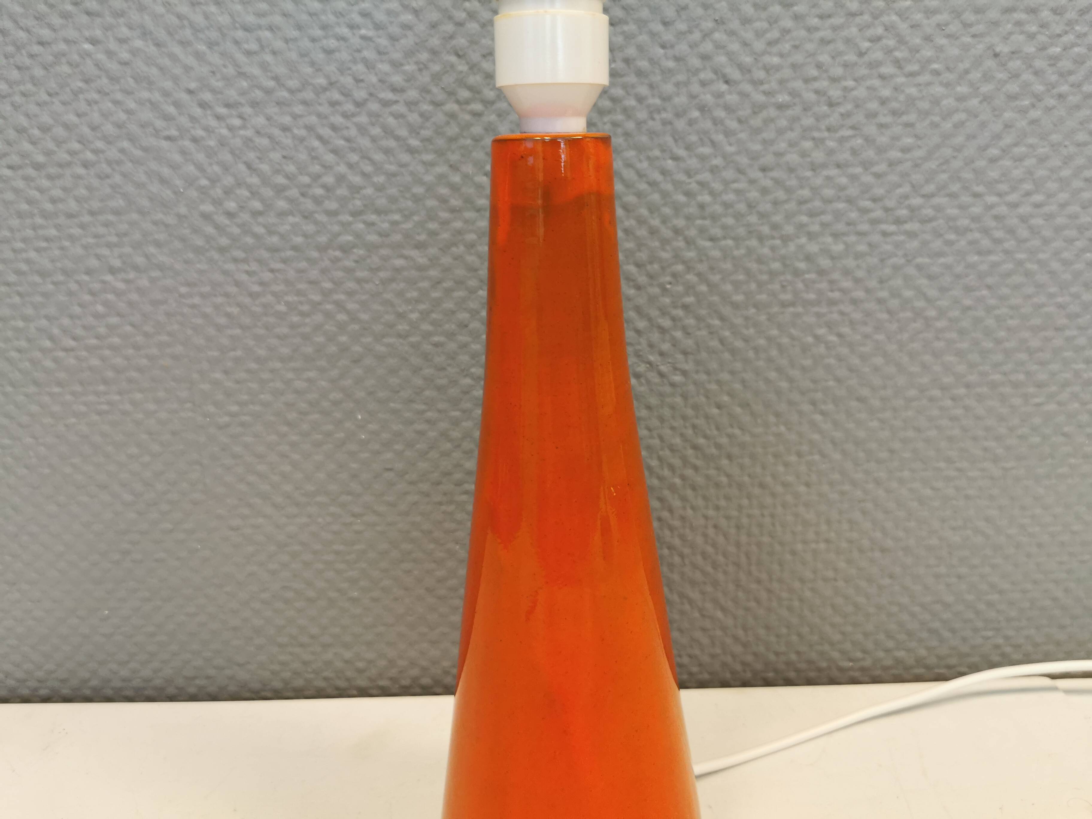 Ceramic table lamp with partial orange glaze.