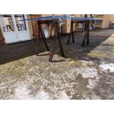 Vintage table with a glass top and smoked plastic trestle legs.