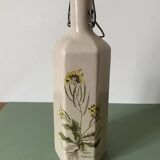 Faceted stoneware bottle signed La Cigogne, floral model (Diplotaxis muralis)