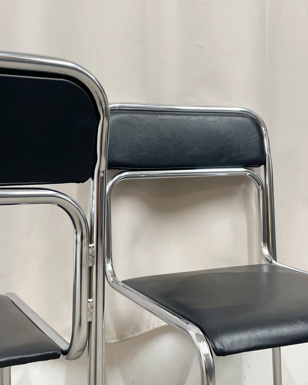 4 chrome metal chairs with black faux leather, 1990