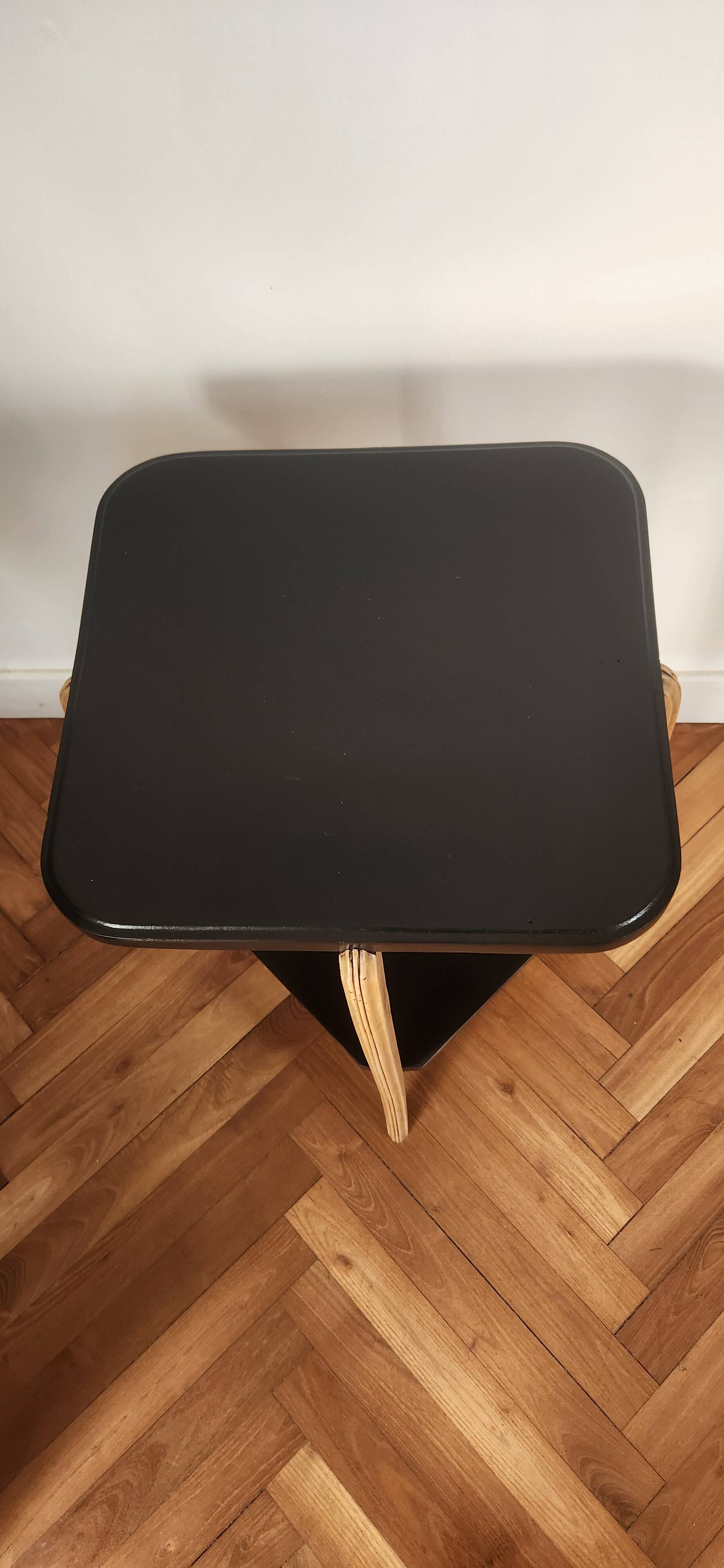 Black lacquered wooden side table with offset tops.