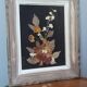 Wood frame dried flowers under glass, black background, vintage