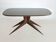 Dining table with a wooden frame and tinted glass top.