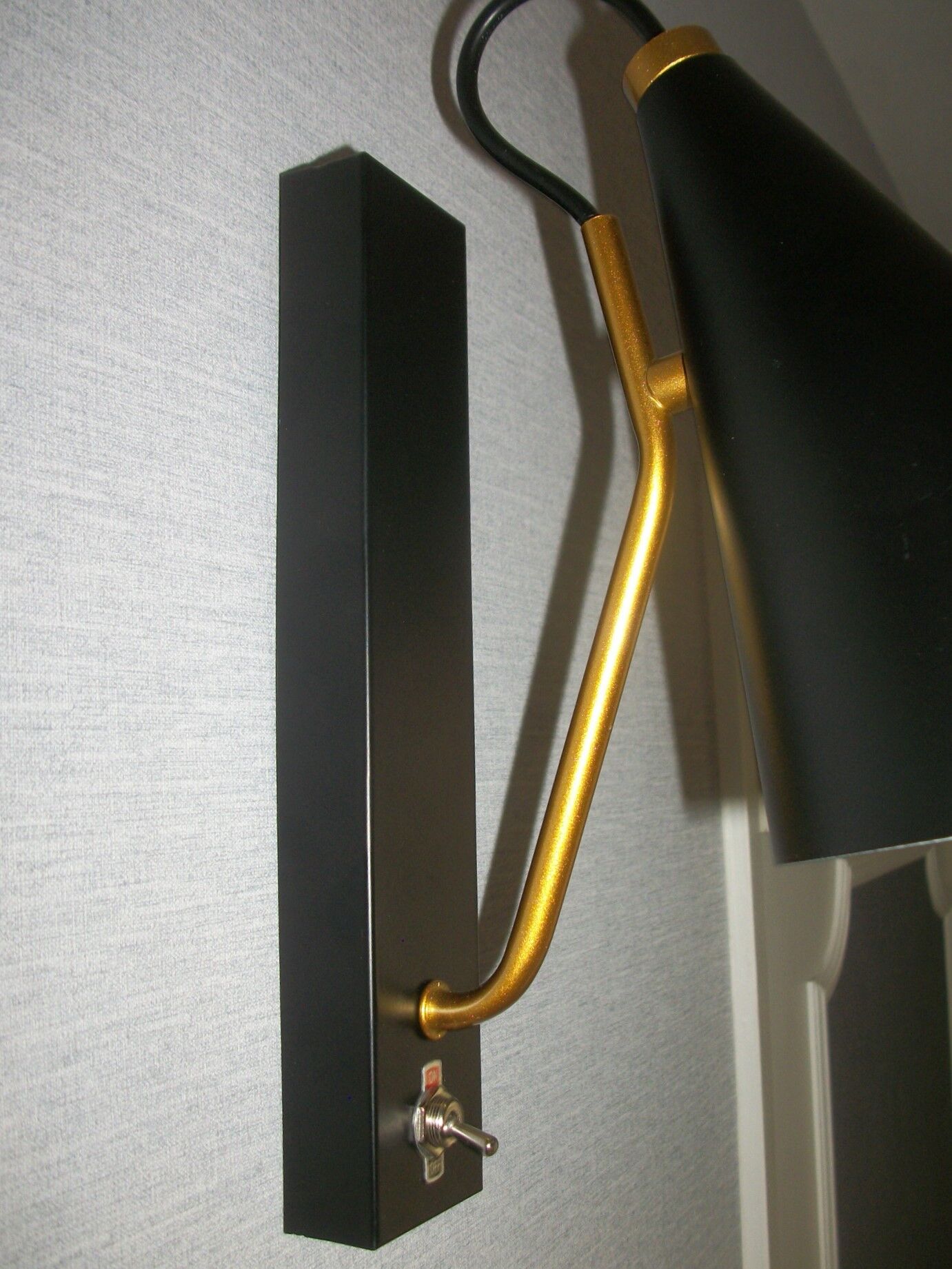Pair of modernist sconces in black and gold metal