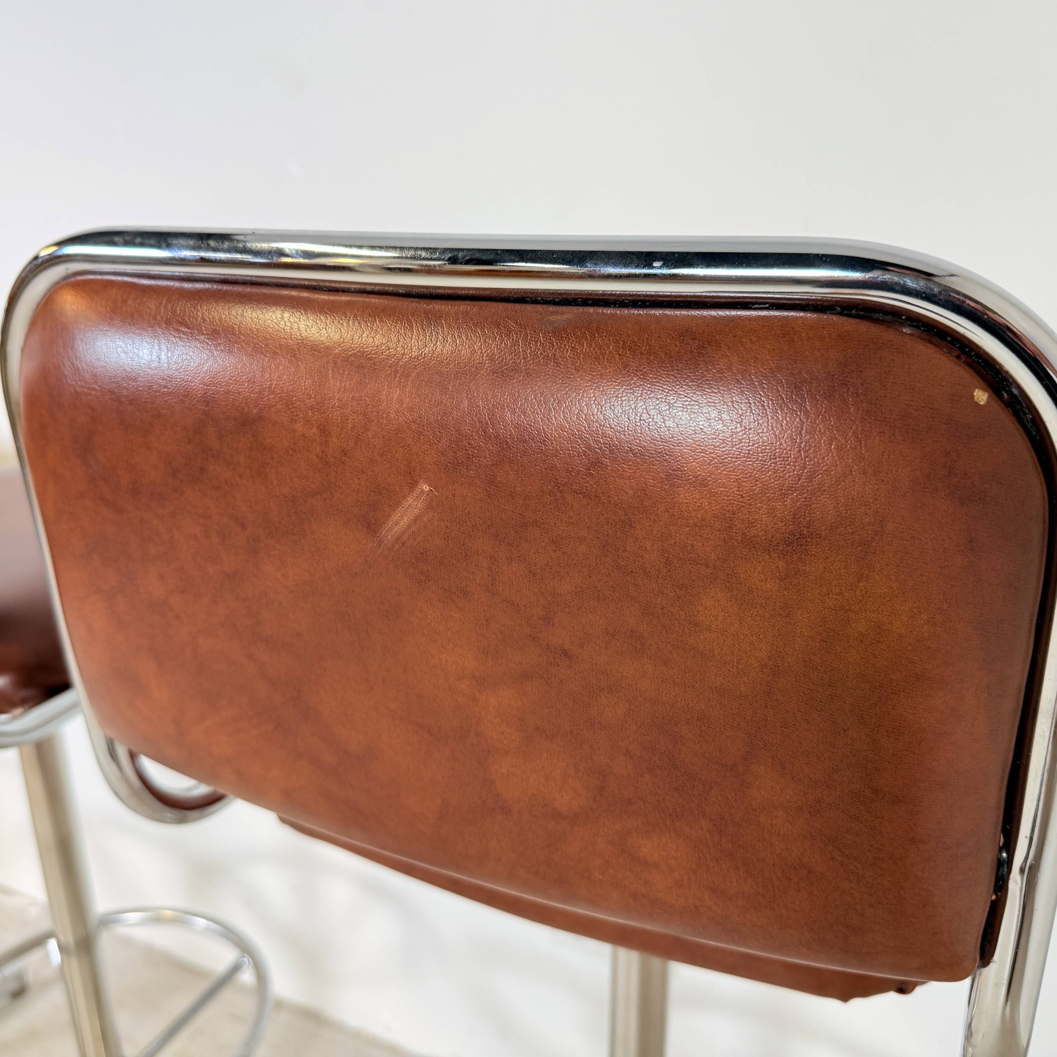 1970s chrome bar stools with cognac-colored faux leather upholstery