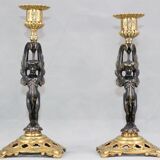 Pair of candle holders in gilded bronze and patinated with a candle