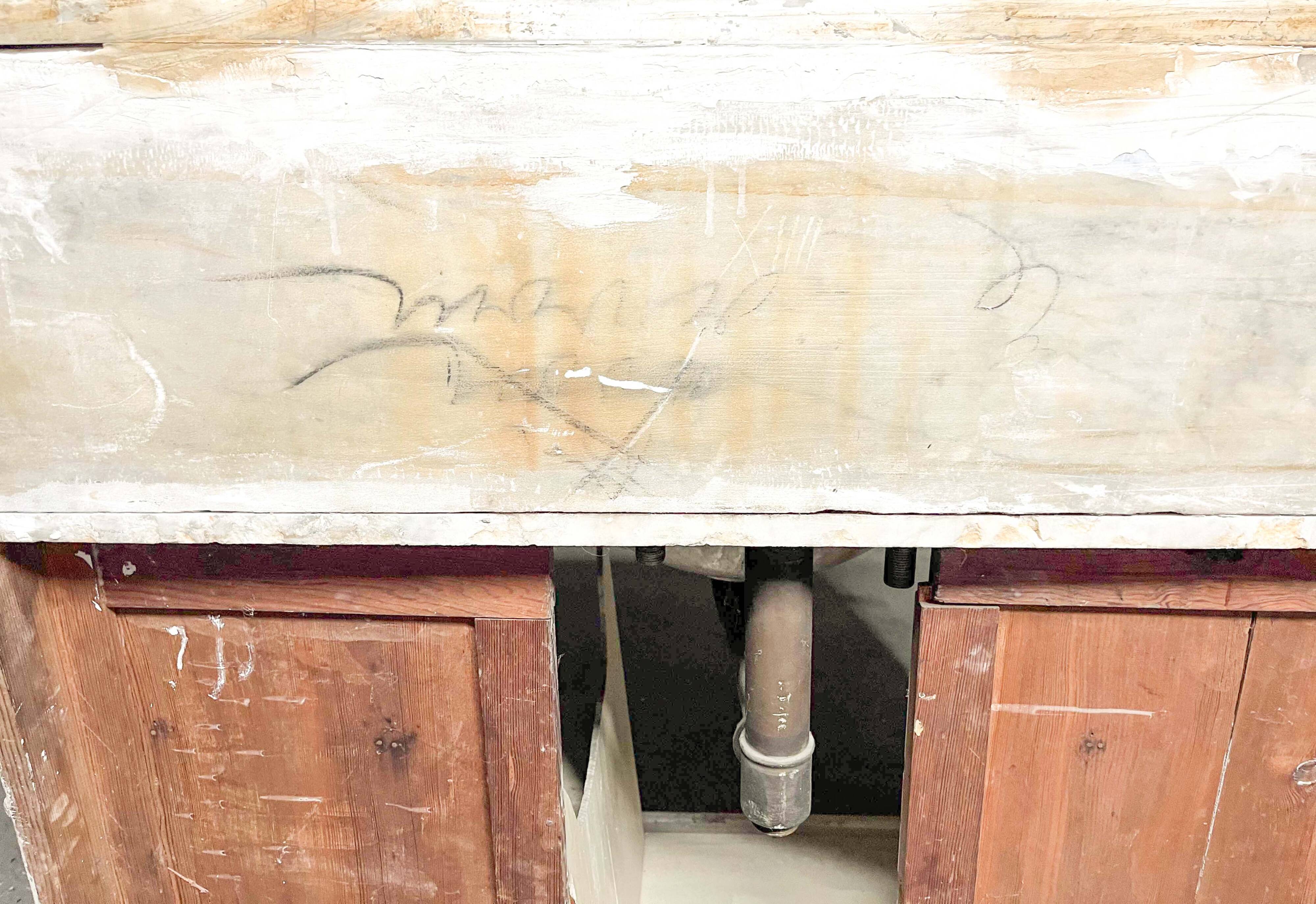 Antique wooden bathroom cabinet with painted finish and white marble.