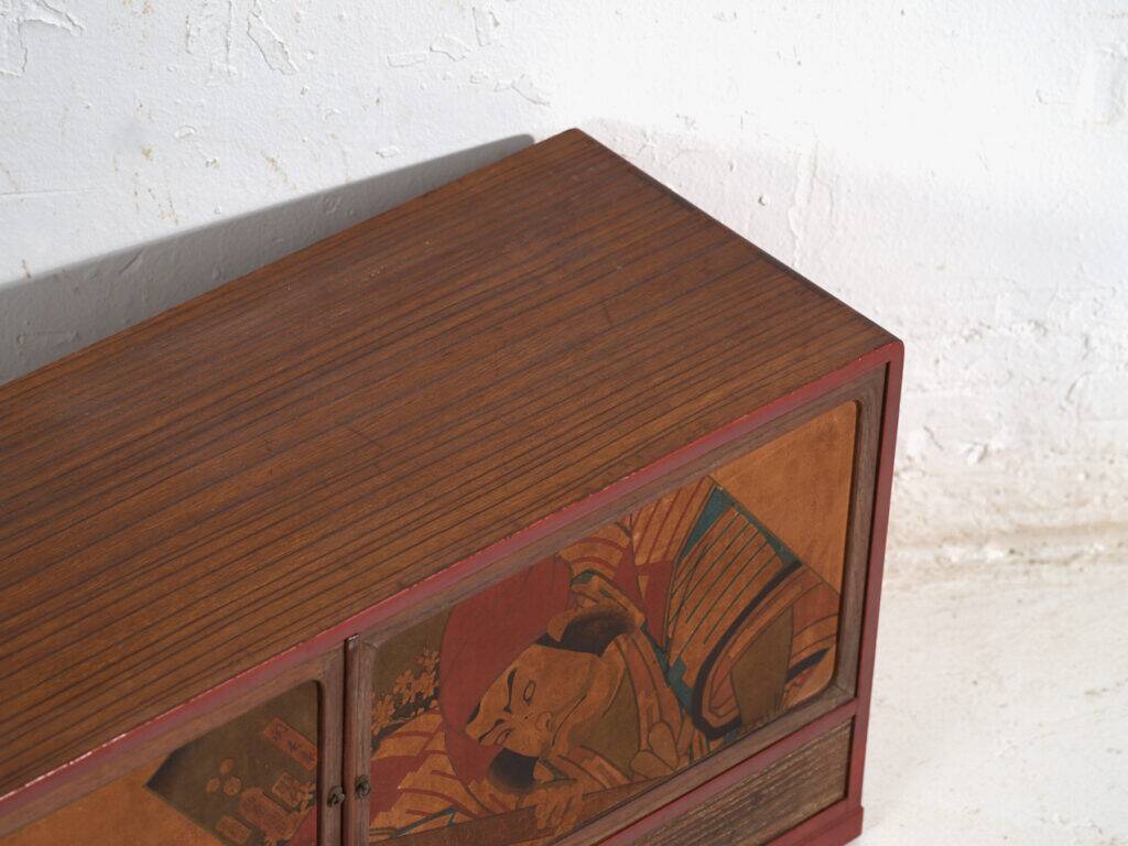 Small Japanese cabinet with sliding doors, Kabuki decoration, made of paulownia wood, early Showa period, circa 1926–1970.