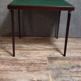 a wooden Bridge game table resting on four thin, straight legs