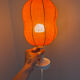 Lamp with a plastic base and a coloured fabric shade in Mid Century style.