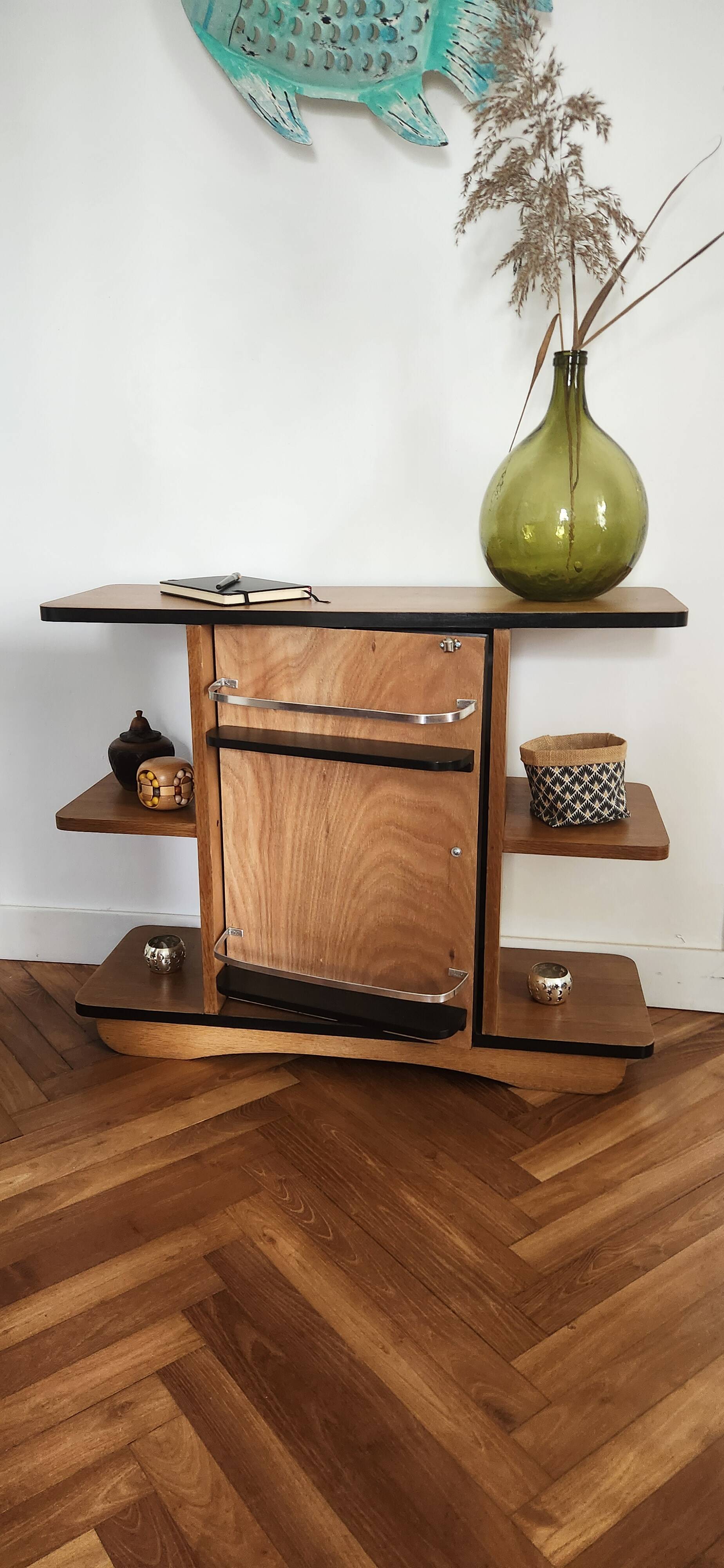 Compact bar cabinet with a pivoting door in black wood.