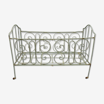 Baby bed in wrought iron with green swirls color decoration of water