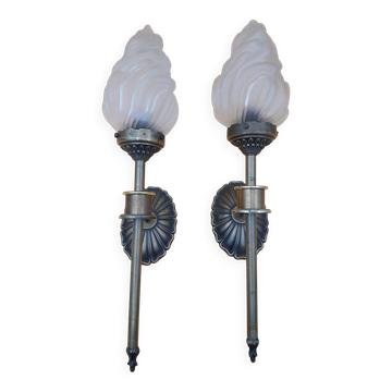 Pair of brass torch wall lights with globe flame.