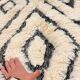 Tapis berbère en laine écrue à motifs noirs