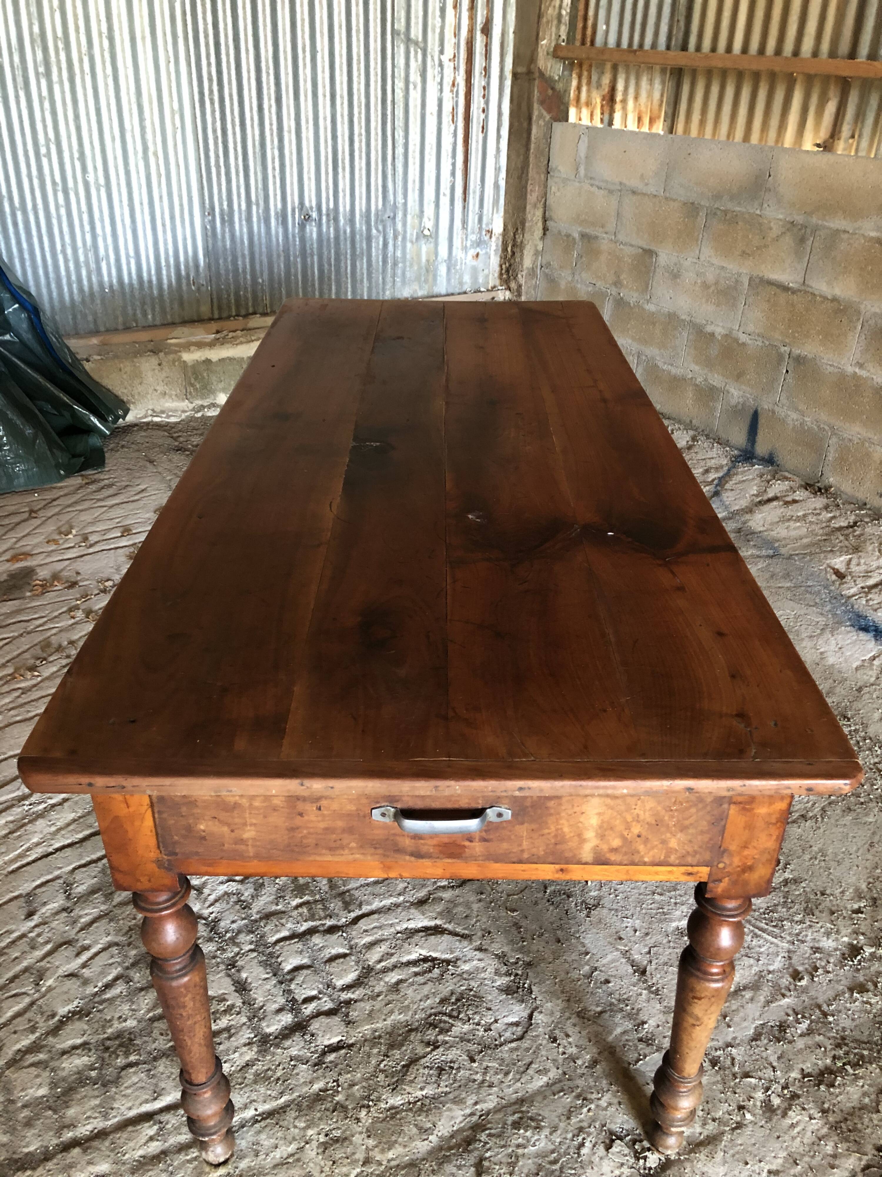 Antique Louis Philippe style farm table in solid cherry wood with turned base.