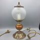 Hollywood Regency bedside lamp in gold metal with a glass globe.