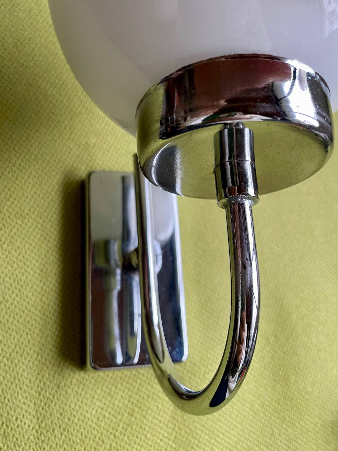 Pair of chrome metal wall lights with white glass globe.