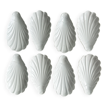 Set of white porcelain ramekins, ribbed shell shape.