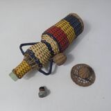 Old bottle dressed in scoubidou style rattan