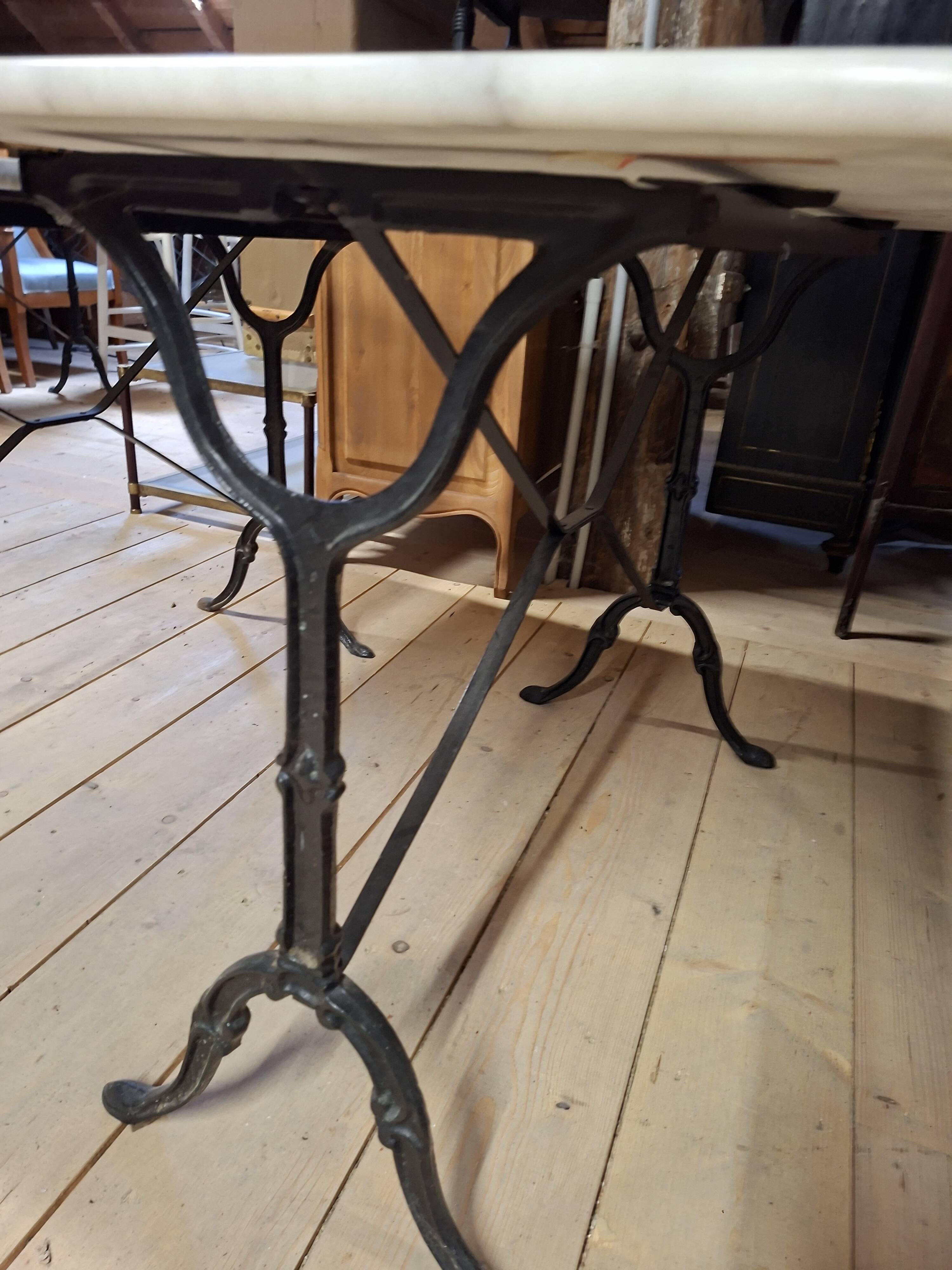 Pair of bistro tables in marble and cast iron.