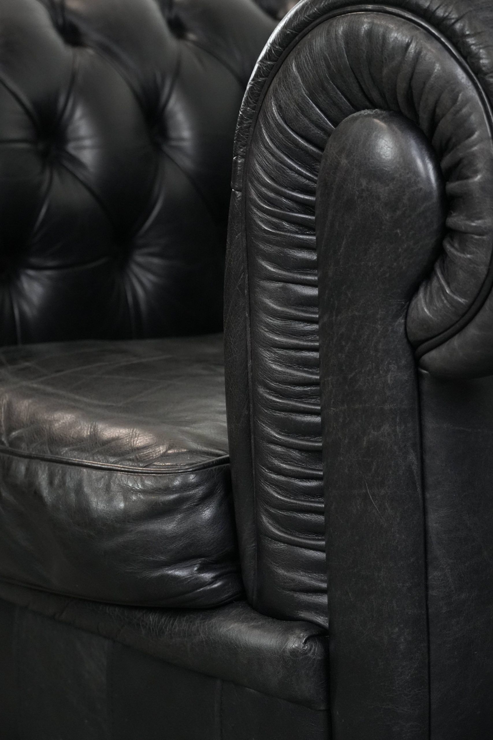 Comfortable black chesterfield armchair made of cowhide leather