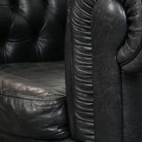 Comfortable black chesterfield armchair made of cowhide leather