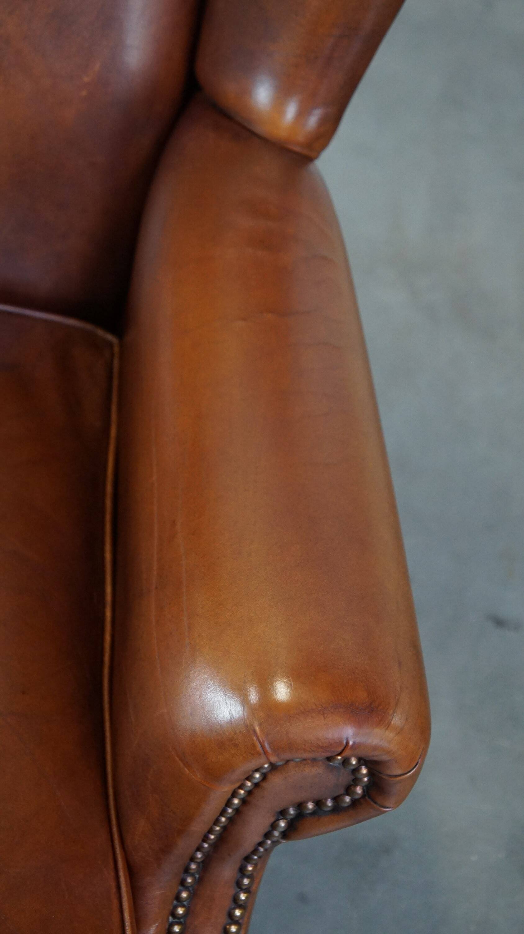 Fauteuil à oreilles en cuir de vachette cognac