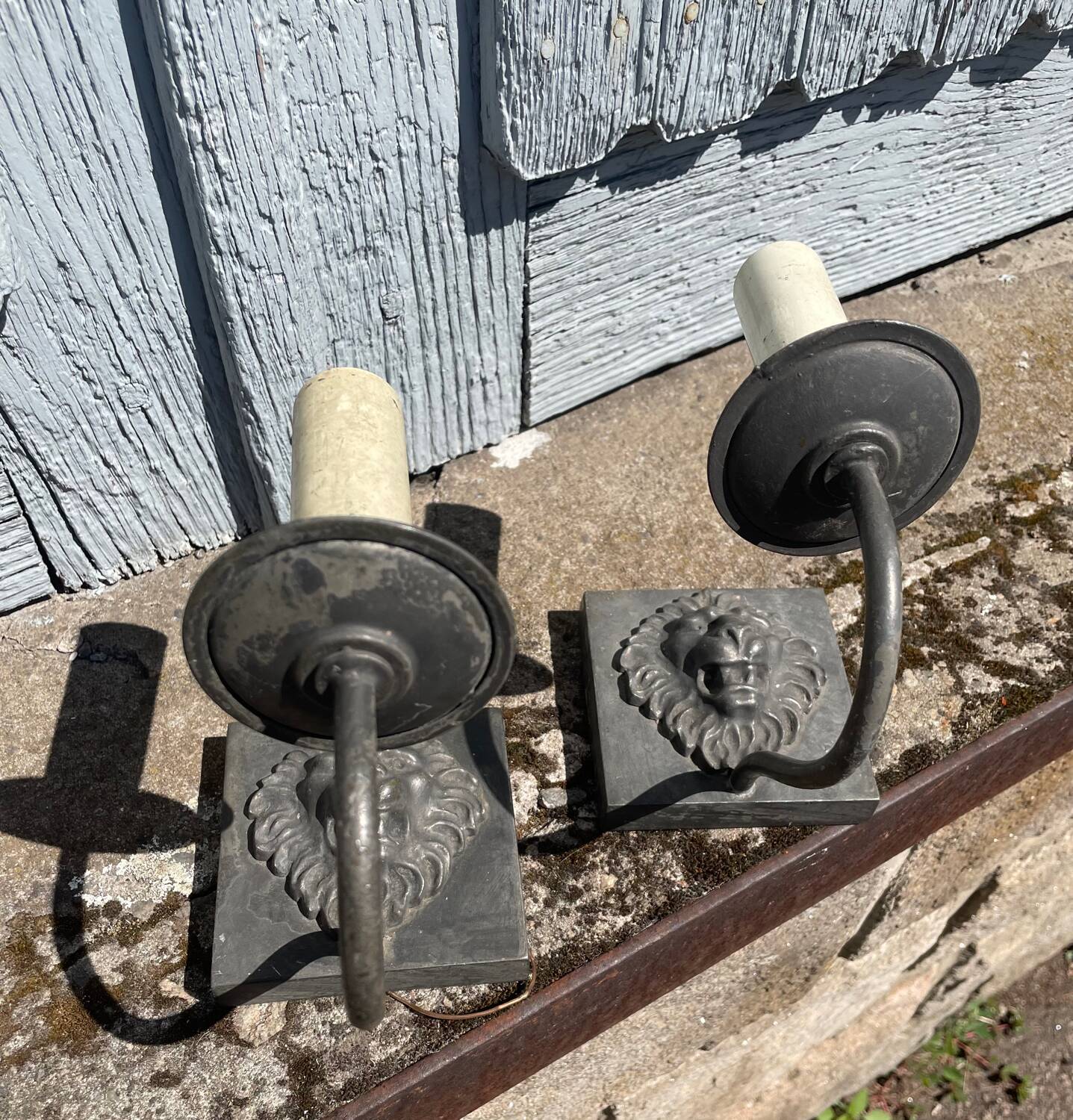 Two lion head wall sconces in tin.