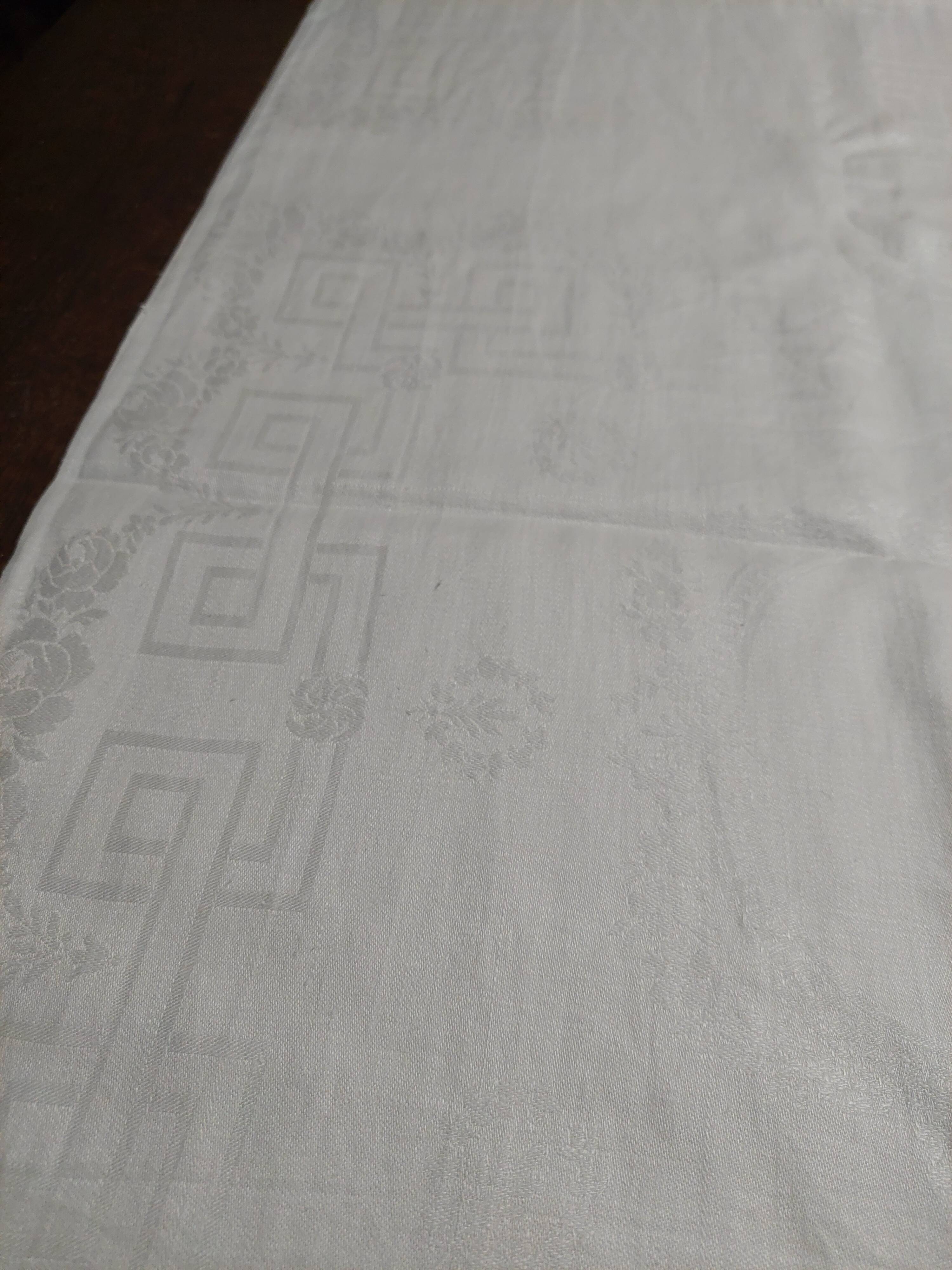 Table napkins set of eleven in a single piece damask linen and silk early 20th century.