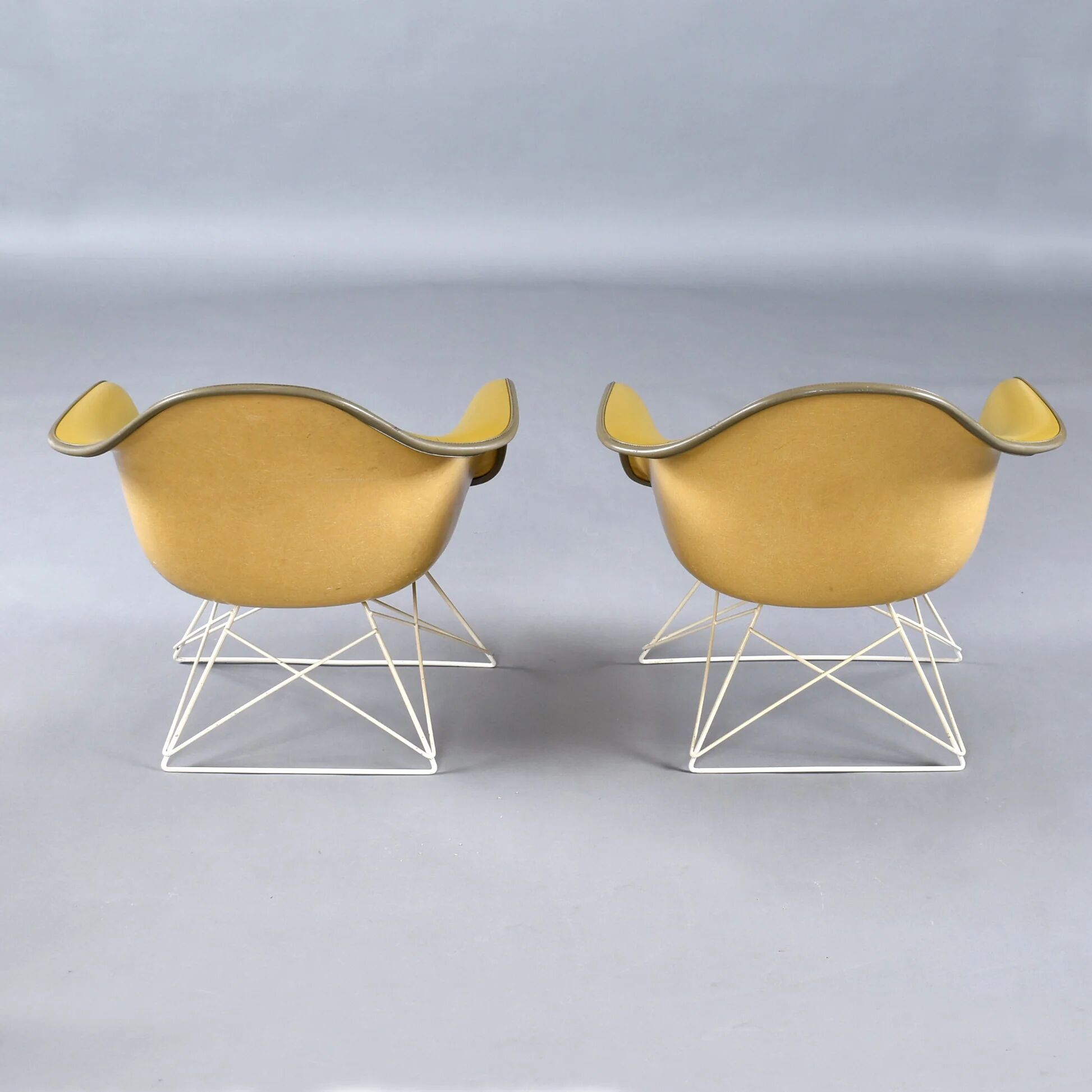Paire de chaises coque LAR Eames pour Herman Miller avec des coussins en Naugahyde jaune.