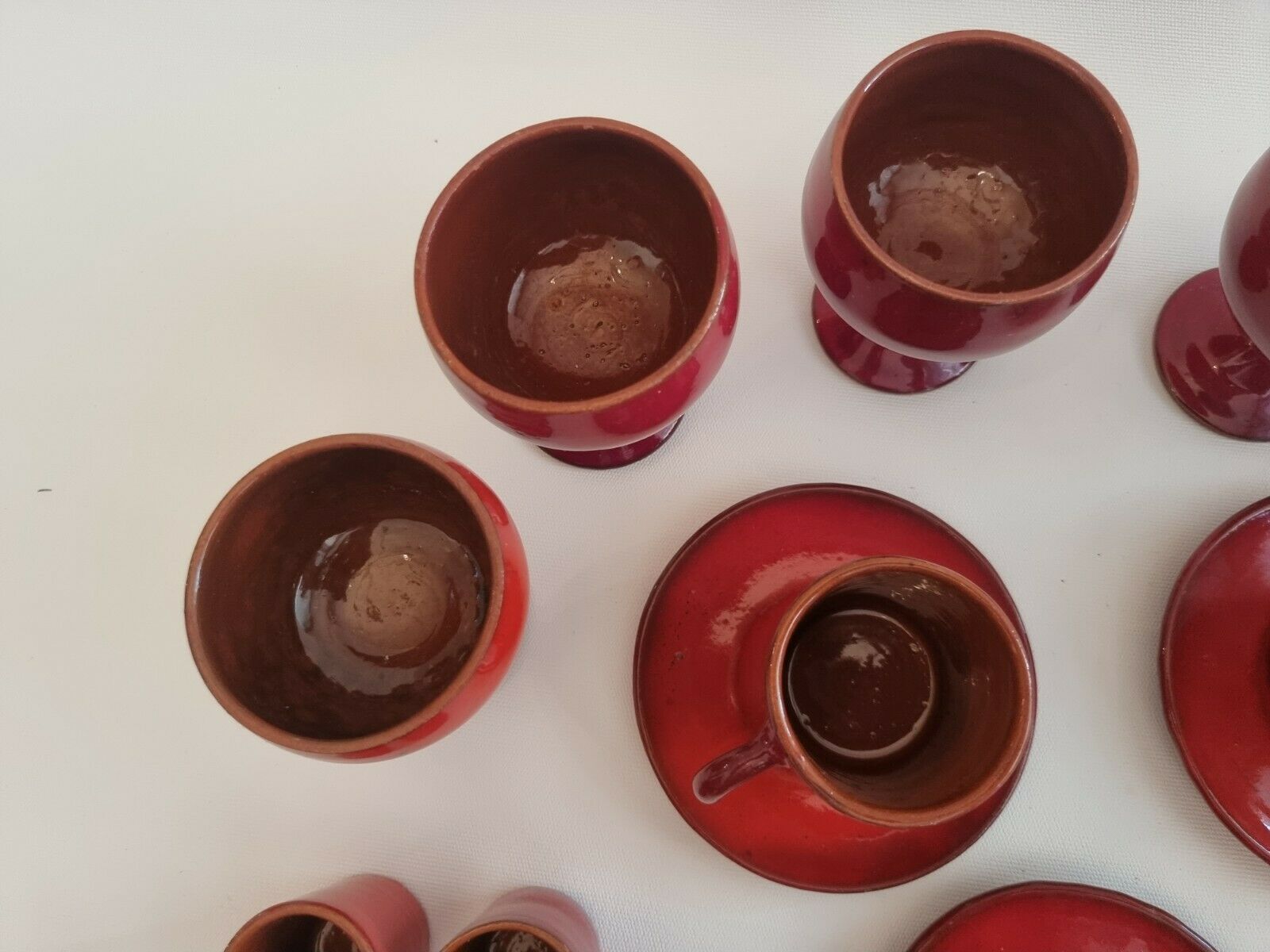 Red enamelled terracotta: cups, saucers, glasses