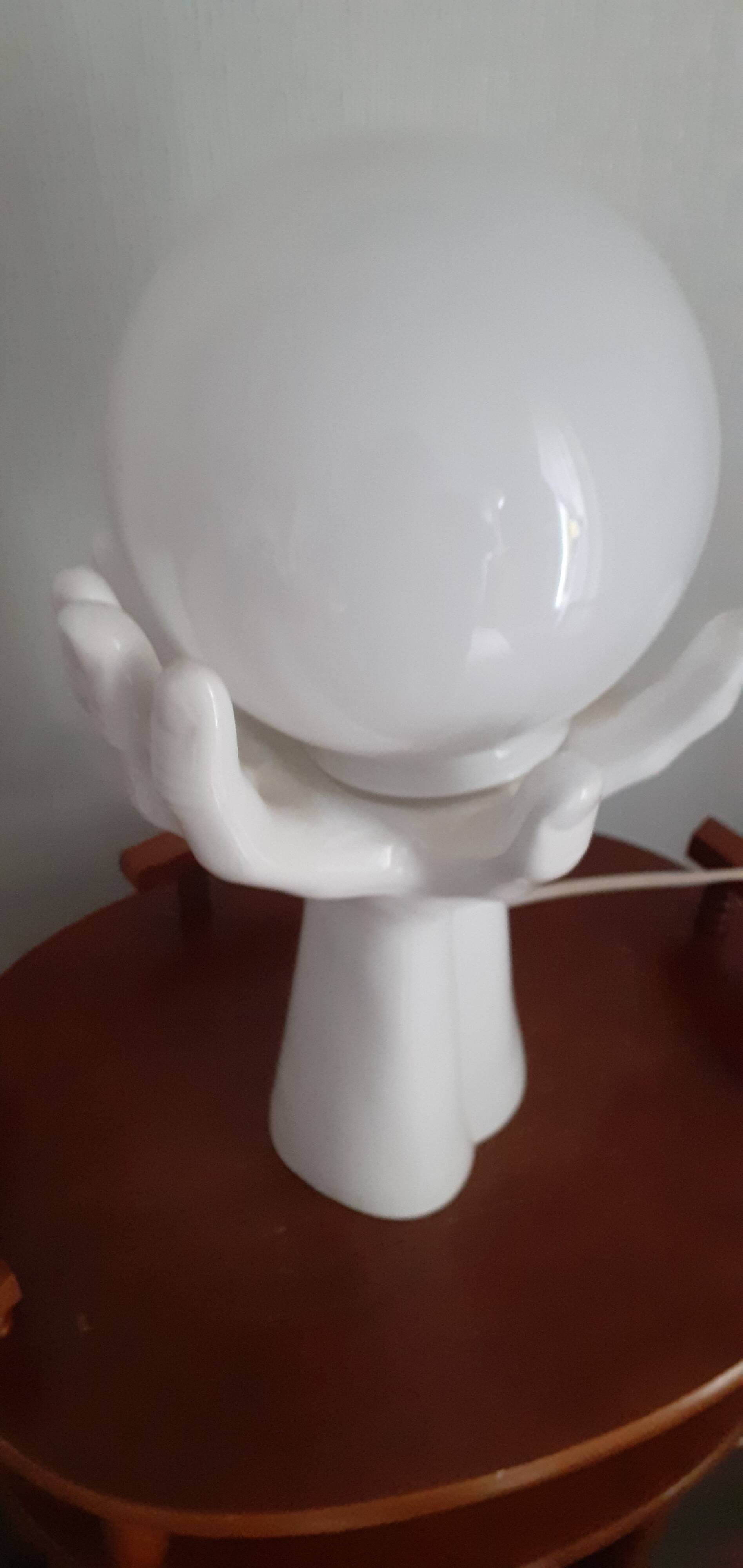 70s lamp two hands embrace an opaline globe