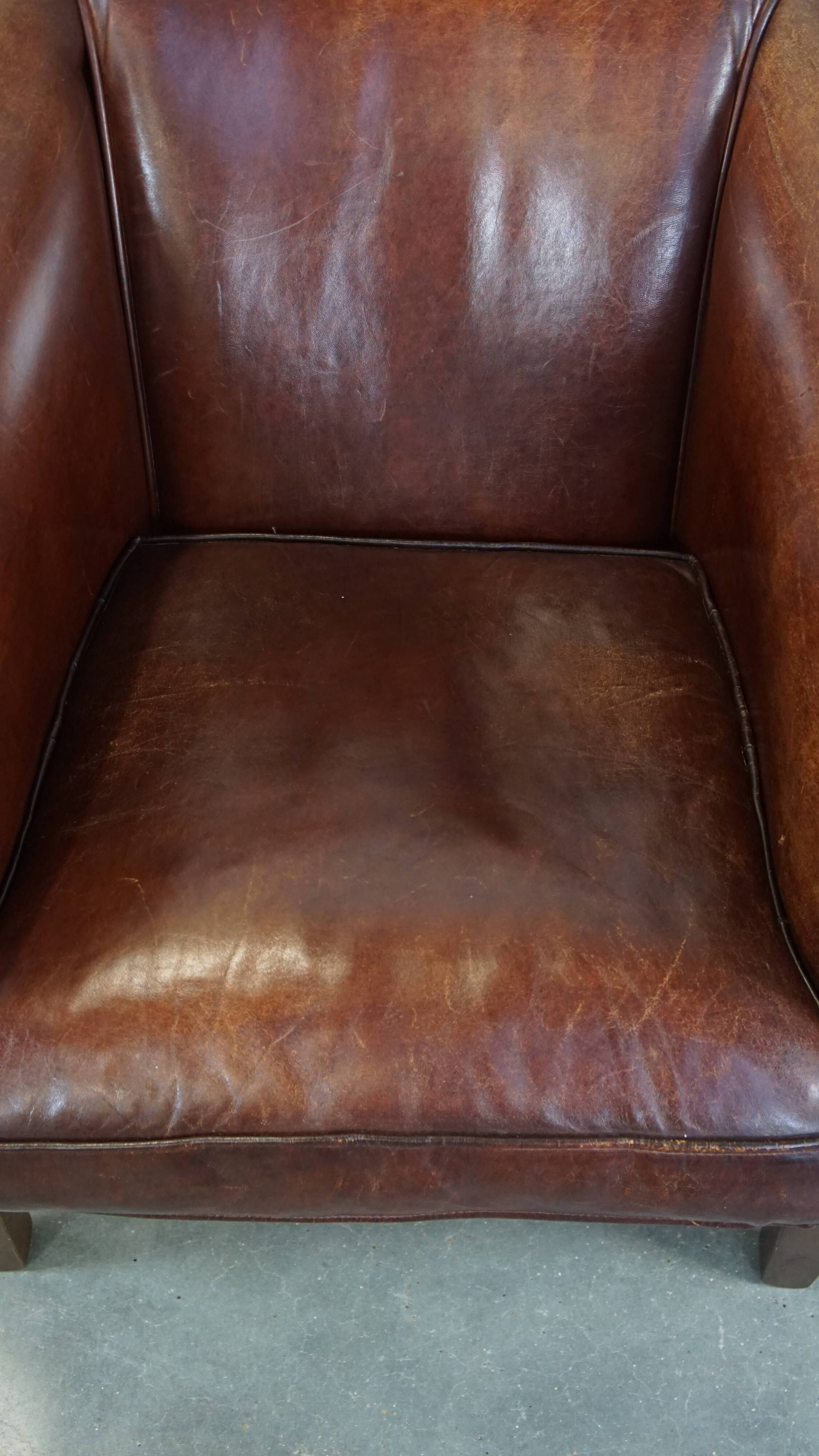 Sheepskin club armchair, correct finishing with decorative nails