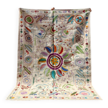 White suzani kilim rug with embroidered multi-colored patterns