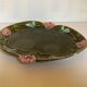 Old khaki green earthenware dish and pink flowers