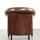 Sheepskin club armchair with deep warm colours and black piping