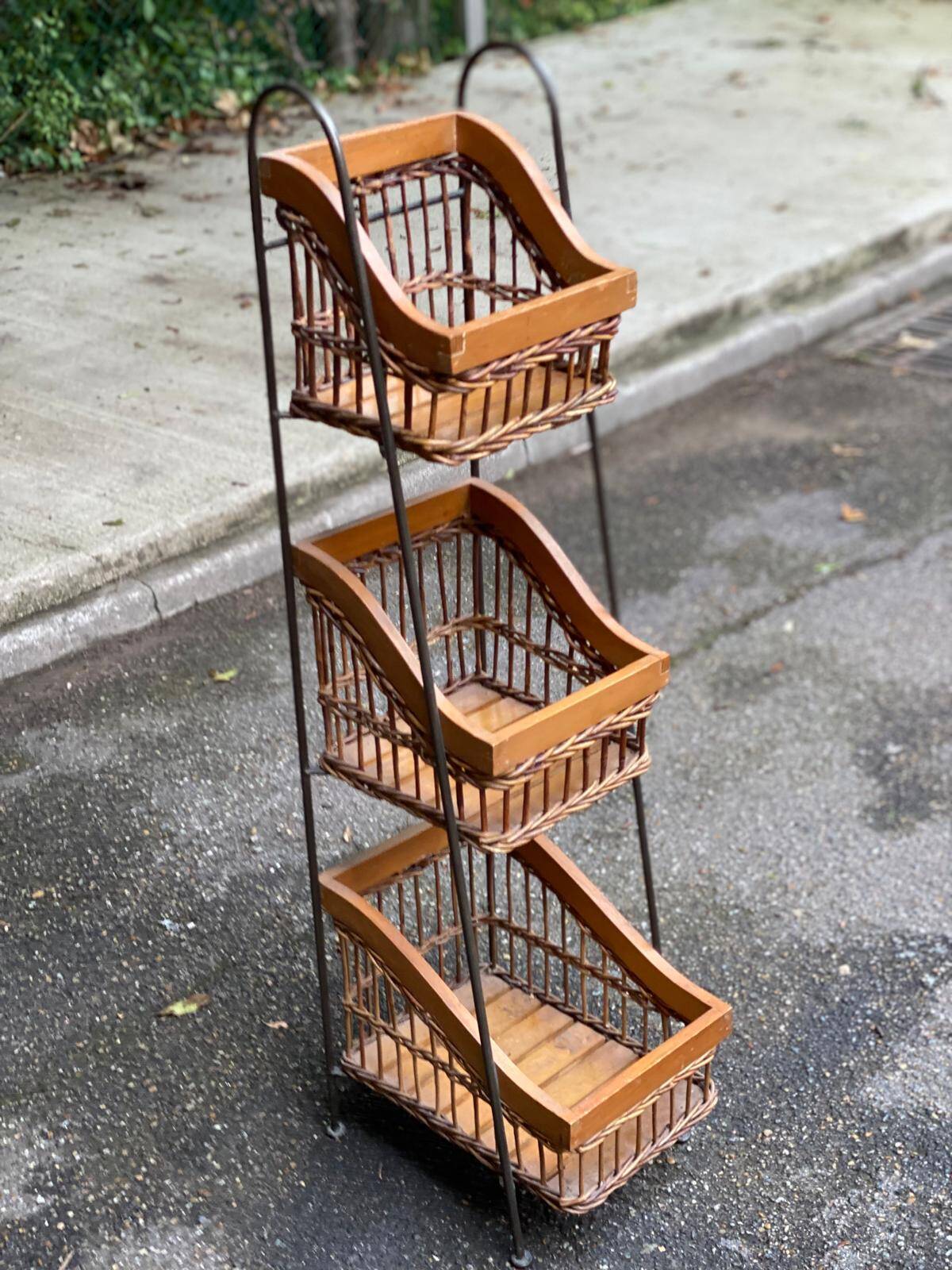Woven rattan and steel display shelf in the shape of a staircase.