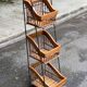 Woven rattan and steel display shelf in the shape of a staircase.