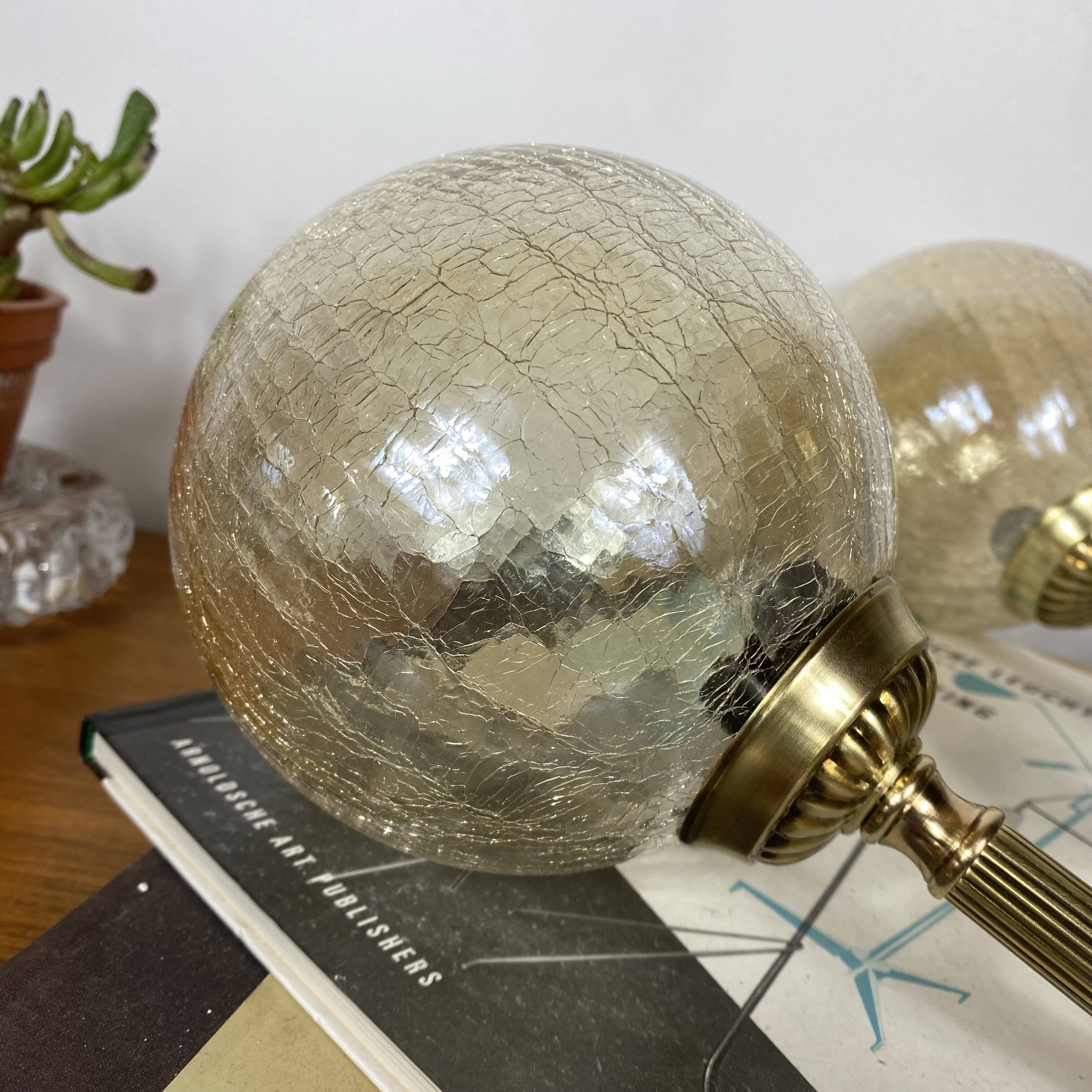 Pair of antique wall sconces torch style brass with glass globes in gold.