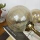 Pair of antique wall sconces torch style brass with glass globes in gold.