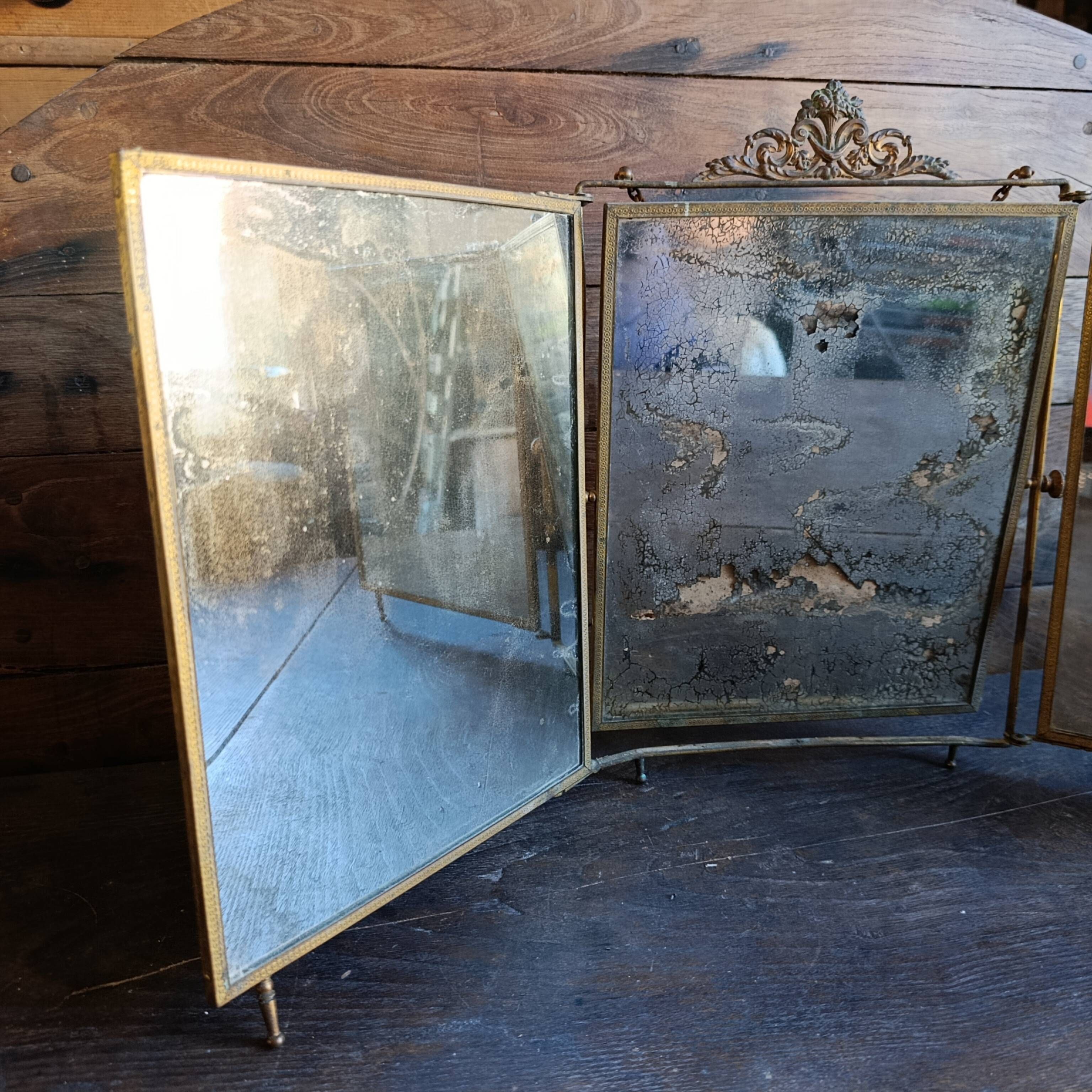Antique French gilt metal triptych vanity mirror with floral crest