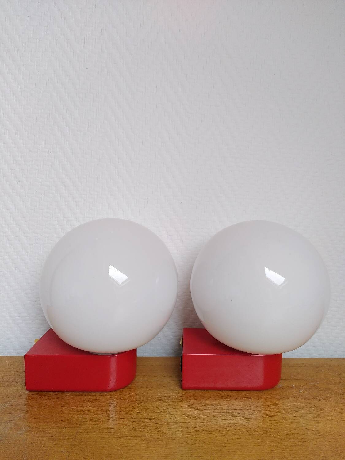 2 postmodern opaline and red metal wall lights, 1980