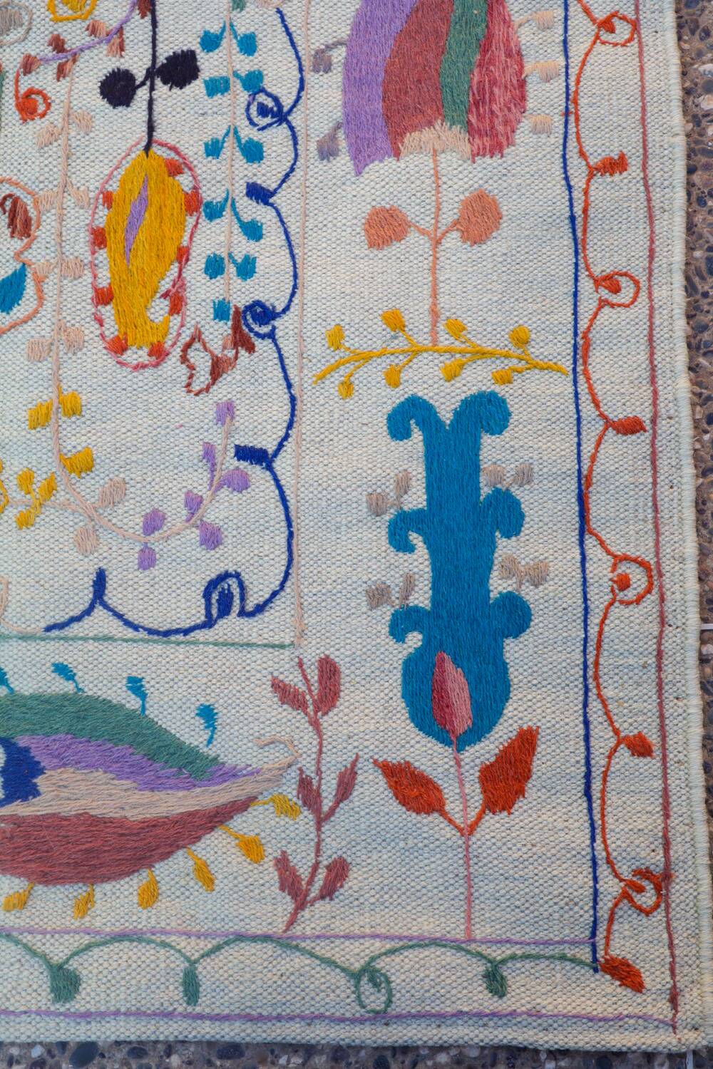 White suzani kilim rug with embroidered colorful patterns