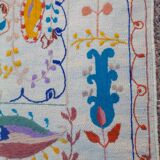 White suzani kilim rug with embroidered colorful patterns