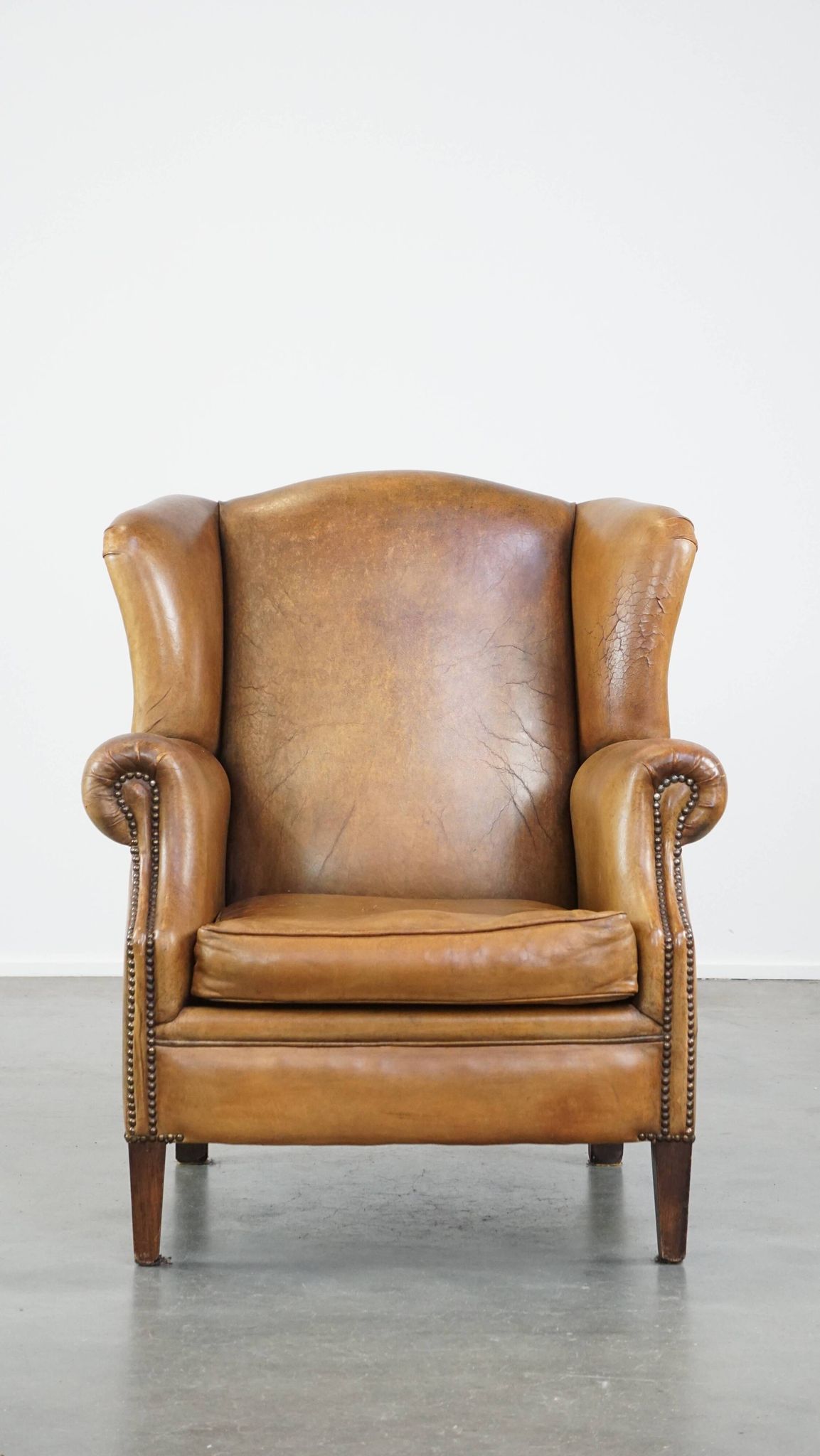 Patinated sheep leather wingback armchair