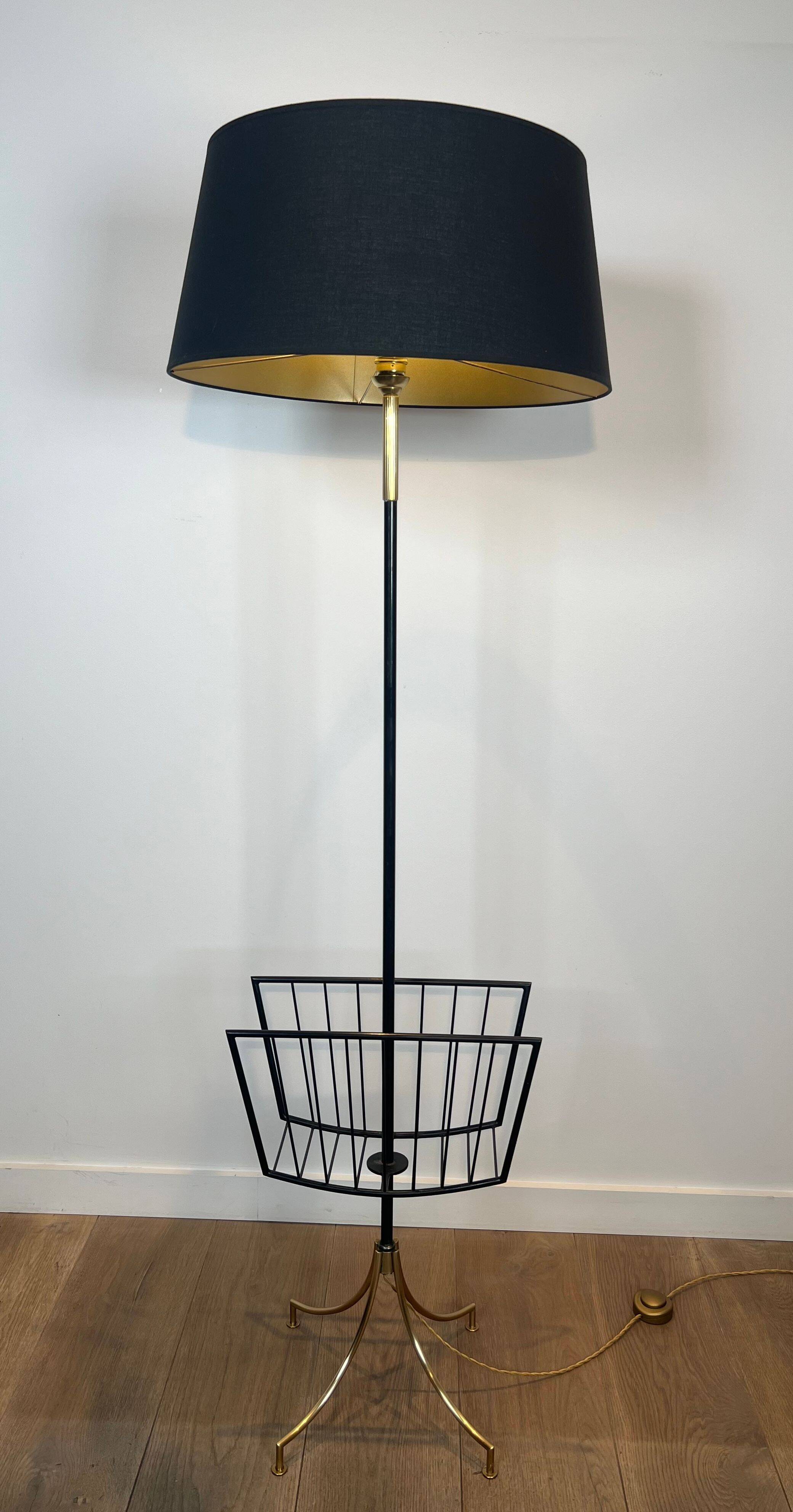 Designer floor lamp in black lacquered metal and brass, incorporating a magazine rack