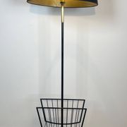 Designer floor lamp in black lacquered metal and brass, incorporating a magazine rack