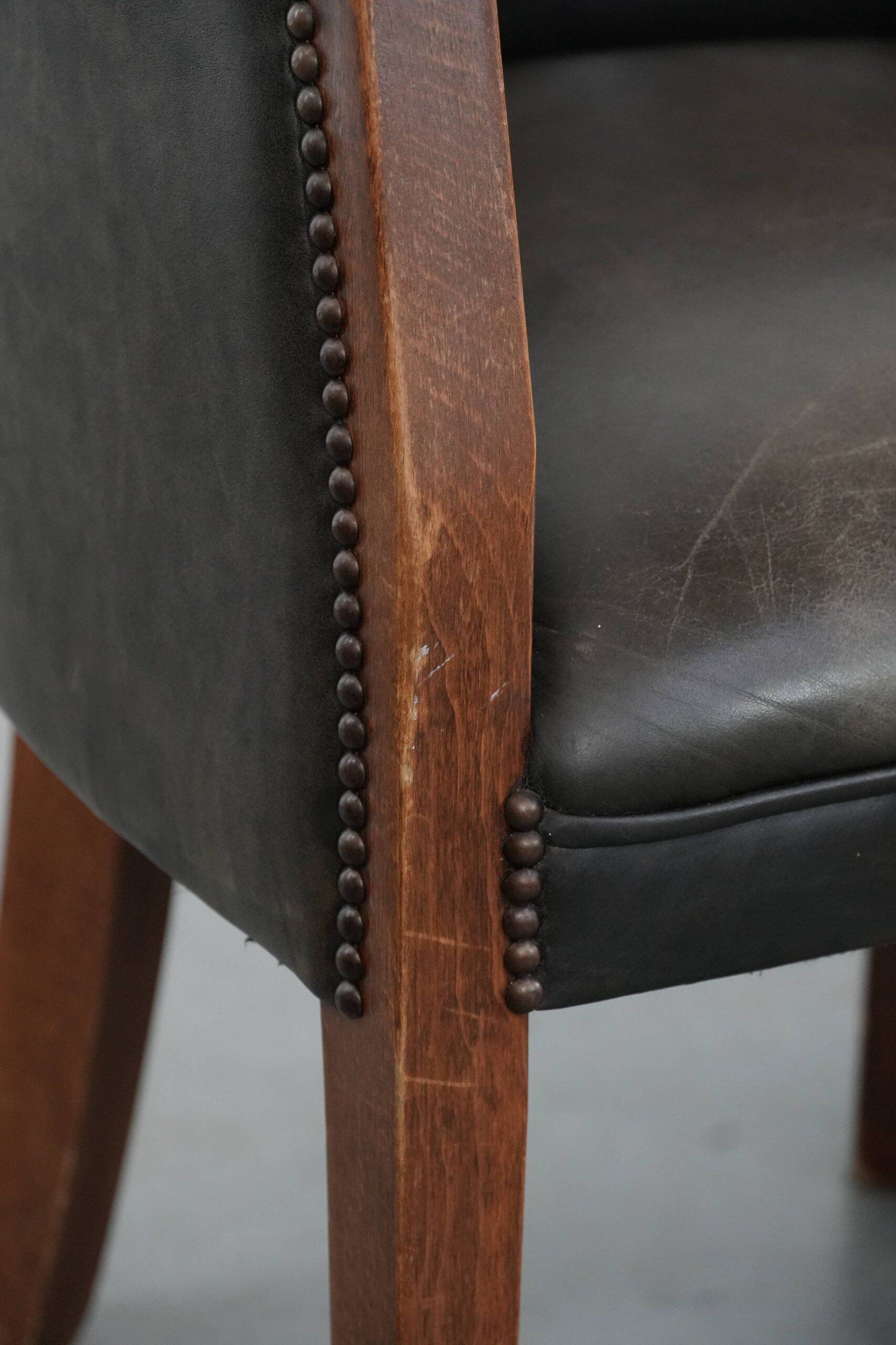 Set of two cowhide and wooden tub chairs with a sturdy colour scheme